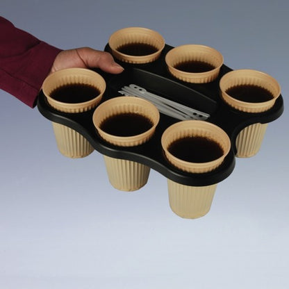 A hand holds a Starpak 3 cup tray (PS, 22.4 x 24.4 x 2.4 cm, black) for six cups, containing beige cups with dark liquid and several white stirring sticks in the middle compartment.
