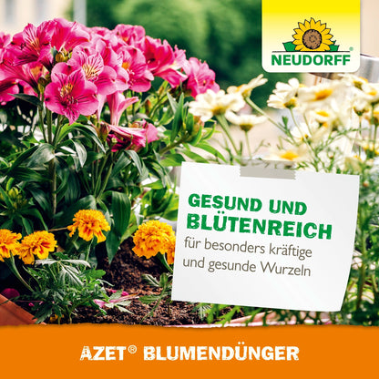 A flower box with blooming pink and yellow flowers stands under a German sign advertising Azet Liquid Flower Fertilizer for healthy growth. The sunflower logo of Neudorff Shop appears in the upper right corner.