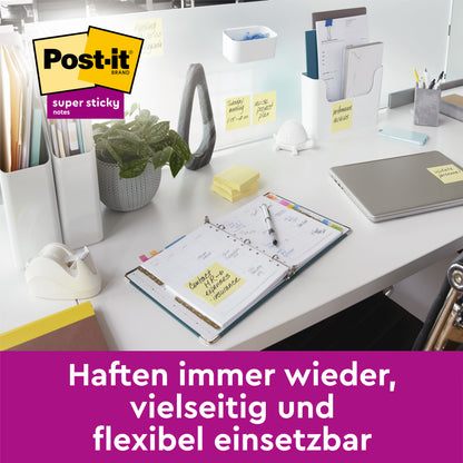 Ein aufgeräumter Bürotisch mit Laptop, Planer und 3M Deutschland GmbH Post-it® Super Sticky Notes, Gelb, 76 mm x 76 mm (90 Blatt/Block, 14+2 Blöcke/Packung), auf verschiedenen Flächen. Text: "Haften immer wieder, vielseitig und flexibel einsetzbar.