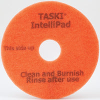 The TASKI Intellipad Combined Cleaning and Polishing Pad for routine cleaning from Diversey Deutschland GmbH & Co. OHG is round, orange, and has a hole in the center with the following imprint: "TASKI IntelliPad, This side up, Clean and polish, Rinse after use."