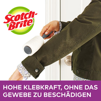 Eine Person benutzt den Scotch-Brite™ Everyday Clean Mini-Fusselroller, 30 Blatt, farbiger Griff von 3M Deutschland GmbH auf dem Ärmel einer dunkelgrünen Jacke. Text: "HOHE KLEBKRAFT, OHNE DAS GEWEBE ZU BESCHÄDIGEN.