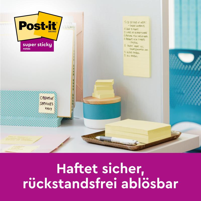 A workspace with Post-it® Super Sticky Notes (76 mm x 76 mm, Promotion, 90 sheets/block, 100% PEFC) from 3M Deutschland GmbH on the wall and on the desk, a folder labeled "Creative Services Kit" and a text in German about secure, residue-free adhesion.