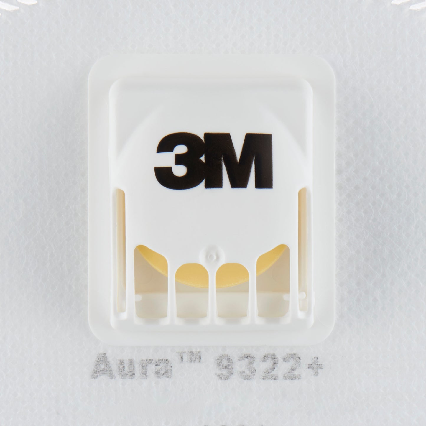 Die Nahaufnahme einer weißen 3M™ Aura™ Comfort Cool Flow™ Partikelmaske 9322+, FFP2, mit Ventil von 3M Deutschland GmbH zeigt das schwarze 3M-Logo, das belüftete Kunststoffventil und einen Teil der Modellbezeichnung unterhalb des Ventils.