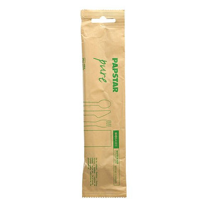 Ein versiegeltes braunes Papierpaket der PAPSTAR GmbH mit der Aufschrift "pure" enthält das umweltfreundliche PAPSTAR Besteckset Holz: Messer, Gabel, Löffel und Serviette aus Papier. Grüne Piktogramme/Text auf der Verpackung weisen auf das umweltfreundliche Besteckset hin.