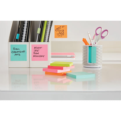Ein aufgeräumter Schreibtisch mit bunten 3M Post-it® Notizzetteln aus der Energetic Collection (76x127 mm, 100 % PEFC, SGSCH-PEFC-COC-110078) in zwei weißen Halterungen, mit Scheren, Stiften und Stapeln, die an Meetings und Mittagessen erinnern.