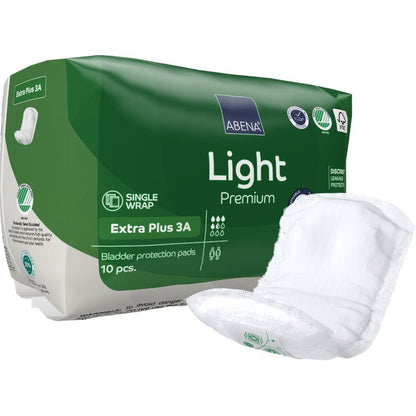 Pictured is a green package of ABENA Light Extra Plus 3A, Premium by Abena Re-Seller GmbH (10 pieces) with a white block on the front. The packaging highlights various product symbols.