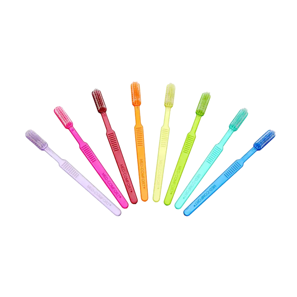 Seven bright AMPri MED-COMFORT Dental PS disposable toothbrushes with toothpaste are neatly arranged in a row. From left to right, the colors are purple, pink, red, orange, yellow, green, and blue. Each has a similar design with soft bristles, perfect for dental care on the go.