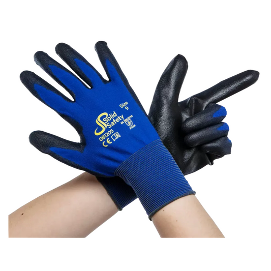 Ein Paar verschränkter Arme mit ultraleichten blauen und schwarzen Sicherheitshandschuhen AMPri SolidSafety Tough Fine Touch strahlt Premium-Qualität aus. Die offene Handfläche des linken Handschuhs zeigt nach vorne, während die rechte die Form einer Fingerpistole hat. Diese Handschuhe zeigen stolz das Logo der AMPri Handelsgesellschaft mbH und Größeninformationen von XS bis XXL und sorgen so für zuverlässige Leistung.