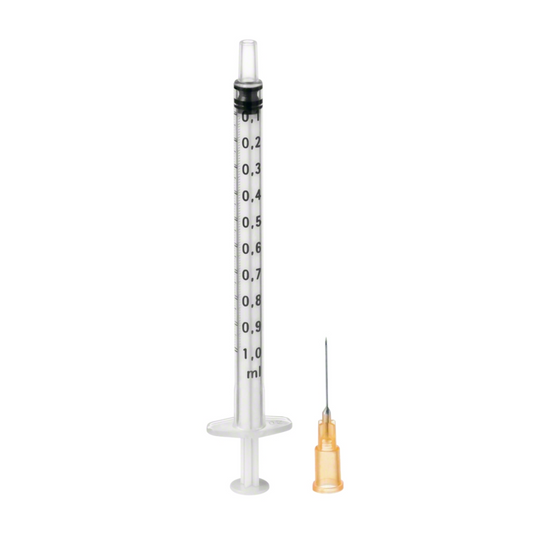 Eine klare medizinische Spritze Omnifix®-F Duo von B. Braun Melsungen AG mit einer Skala bis 1 ml, neben einer separaten Sterican Kanüle mit einer orangefarbenen Kappe, vor einem