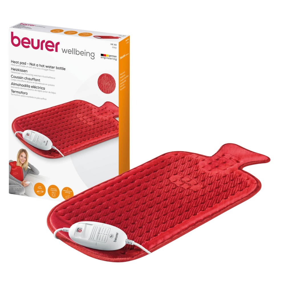 Image of a Beurer HK 44 heating pad by Beurer GmbH in red with a wired controller. In the background, the product packaging is visible, showing the hot water bottle design and the 3 temperature settings of the heating pad. The packaging displays the product name "Beurer HK 44 Heating Pad | Pack (1 piece)" as well as multilingual text and the CE marking.
