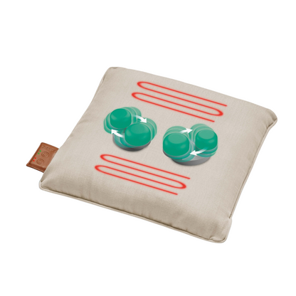A beige Beurer battery massage cushion MG 139 with a brown label on the side shows graphics of four green rotating spheres and three red horizontal waves arranged in an alternating pattern. The graphics likely represent a design related to the Shiatsu massage or heat function features.