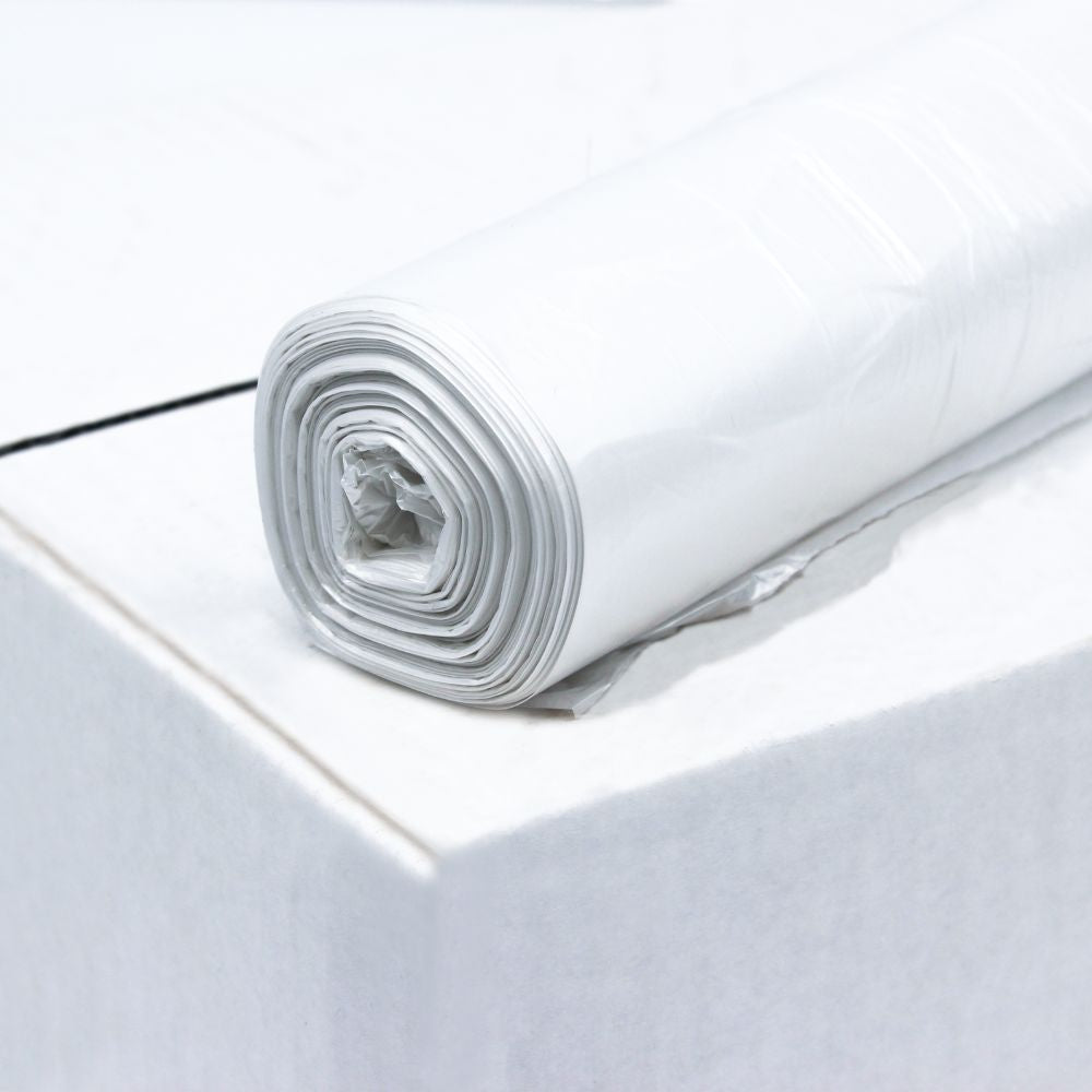 A roll of DEISS HDPE garbage bags 60 liters, 59984 in white from EMIL DEISS KG (GmbH + Co.) lies on the edge of a white box, with the bags neatly rolled and partially unpacked in the middle.