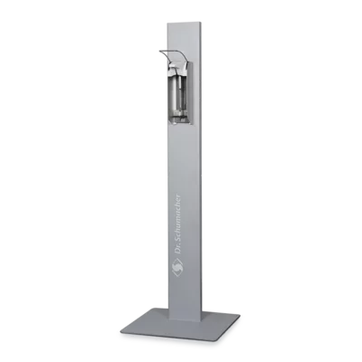 Der Dr. Schumacher Desipoint | Stück (1 Stück) der Dr. Schumacher GmbH ist ein hoher, rechteckiger Handdesinfektionsmittelspender mit Metallic-Finish auf einem flachen, quadratischen Sockel, ideal für hygienische Desinfektionsmittel und Oberflächenreinigung auf einem schlichten weißen Untergrund.
