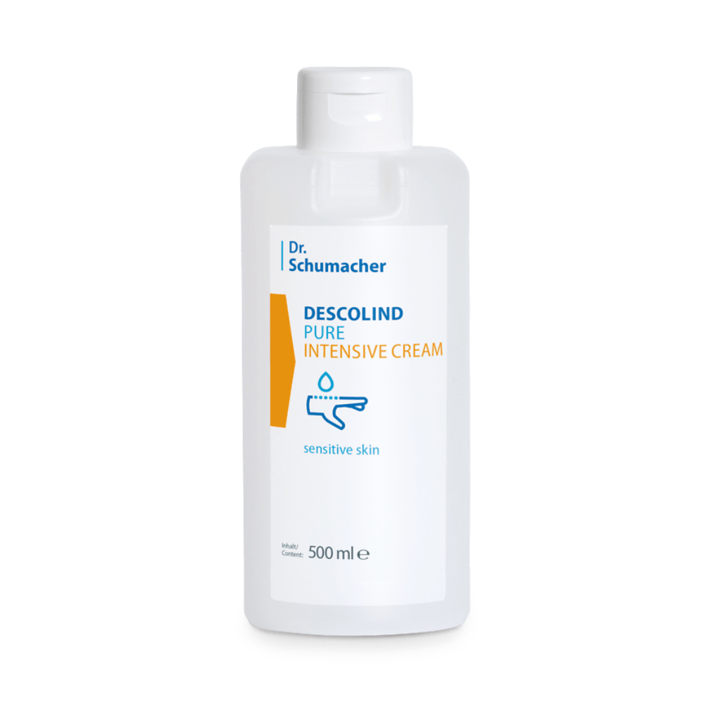 Eine weiße Plastikflasche mit der Aufschrift „Dr. Schumacher Descolind Pure Intensive Cream“ für empfindliche Haut, die 500 ml des Produkts enthält. Die Flasche ist mit blauen und orangefarbenen Designelementen versehen und stammt von der Marke Dr. Schumacher.