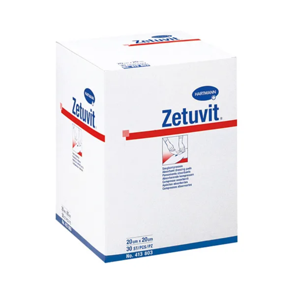 Eine weiße Schachtel mit unsterilen Saugkompressen Hartmann Zetuvit der Paul Hartmann AG mit blau-rotem Markenaufdruck. Auf der Schachtel sind Text und Bild zu sehen, die die Saugkompresse veranschaulichen.