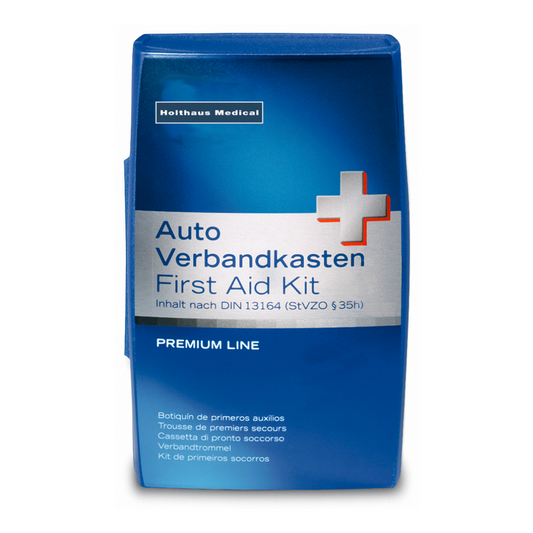 Blauer medizinischer Verbandskasten mit weißem Kreuz und mehrsprachiger Aufschrift „Holthaus Premium Verbandskasten“, entsprechend der Norm DIN 13 164.