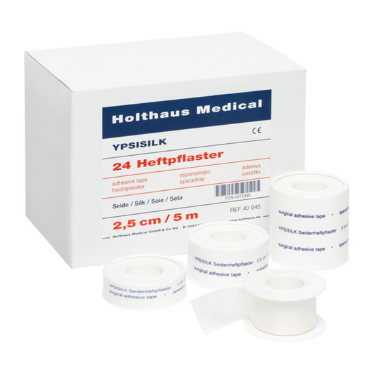 Eine Schachtel YPSISILK Heftpflaster von Holthaus Medical mit vier Rollen des Pflasters, jede mit Text beschriftet. Die Schachtel ist weiß und blau und mit Text und Logos versehen.