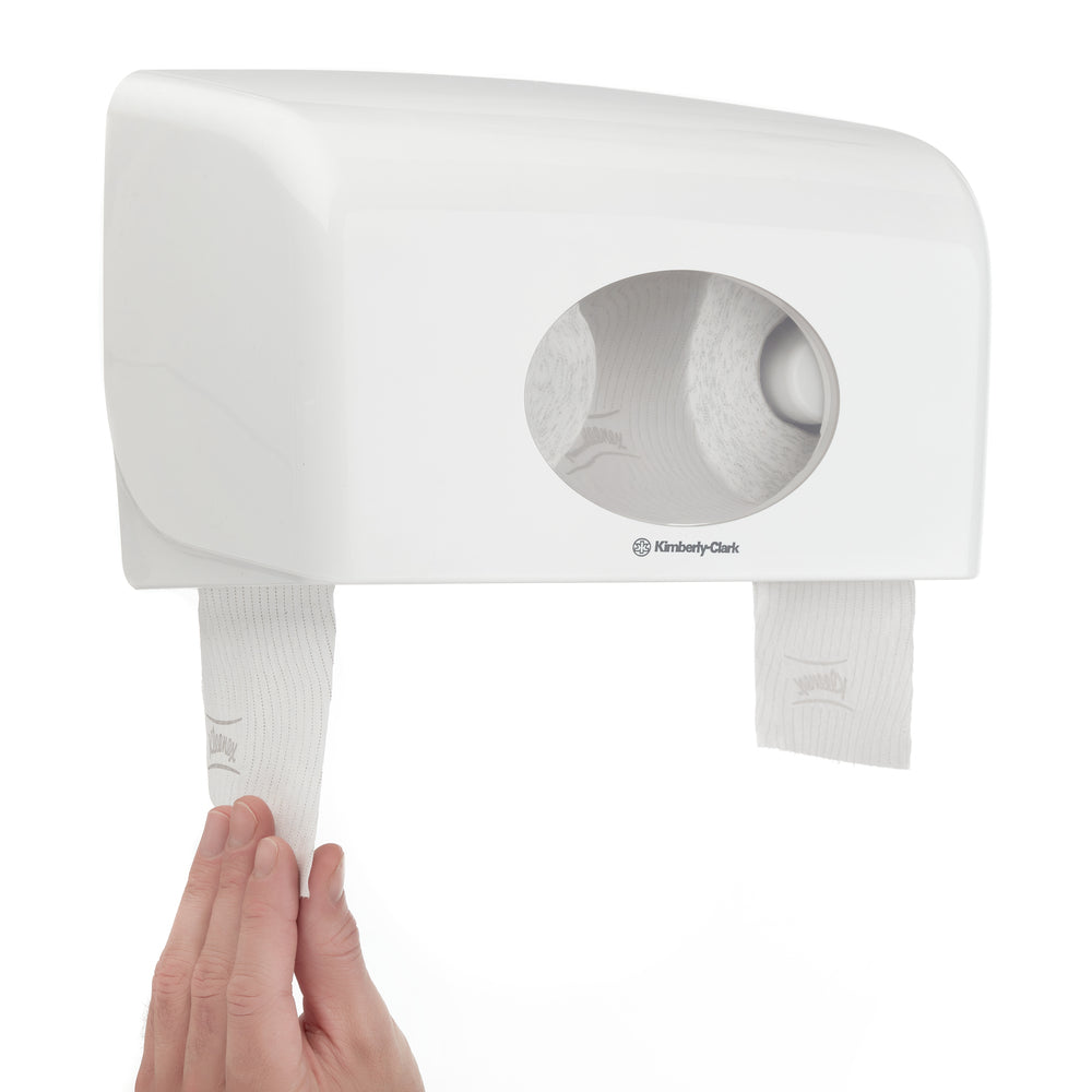 Eine Hand zieht die Kimberly-Clark GmbH Kleenex® Toilettenpapierrollen (weiß, 8 Pack x 12 Kleinrollen, je 250 Blatt) aus einem Doppelwandspender mit ovalem Fenster - ideal für die Verwendung mit diesem Karton (8 Päckchen).
