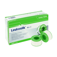 Pictured is a box of BSN Medical GmbH Leukosilk roll bandages (9.2 m x 2.5 cm, pack of 12 rolls) containing three white strips on green spools; the multilingual box highlights how easy it is to secure dressings and notes that the bandages can be removed without leaving any residue.