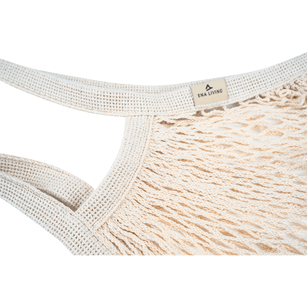 Nahaufnahme des beigen ENA Living Einkaufsnetzes der Abena Re-Seller GmbH mit dicken, geflochtenen Griffen und einem kleinen "ENA LIVING"-Schild. Ideal für umweltbewusste Einkäufe. Verpackungseinheit: Karton (24 Packungen), Hintergrund: weiß.