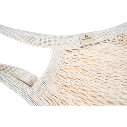Nahaufnahme des beigen ENA Living Einkaufsnetzes der Abena Re-Seller GmbH mit dicken, geflochtenen Griffen und einem kleinen "ENA LIVING"-Schild. Ideal für umweltbewusste Einkäufe. Verpackungseinheit: Karton (24 Packungen), Hintergrund: weiß.