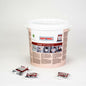 A large white bucket labeled "Rational Cleaner Tabs | Bucket (100 pieces)" from Rational AG prominently displays its product information. In front of the bucket, three individually wrapped cleaner tabs are arranged on a flawlessly white surface, making them ideal for use in CombiMaster Plus and SelfCooking Center devices.