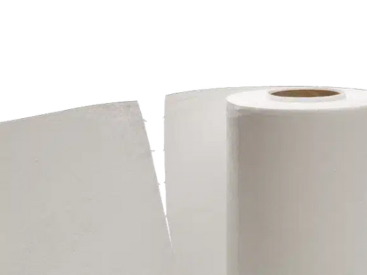 Eine Rolle Vileda MicroRoll-Papiertücher steht vor zwei Stapeln weißer Papierblätter vor einem hellgrauen Hintergrund.