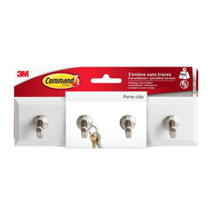 A package of the Command™ Quartz Key Rack, model HOM18-Q, from 3M Deutschland GmbH is shown with three metal hooks for key storage. The keys hang from the middle hook, and the French label highlights the quick and easy installation.