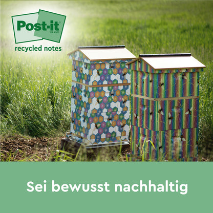 Zwei bunte Bienenstöcke stehen auf einer Wiese, darüber ein grünes Post-it® Super Sticky 100% Recycling Notes Logo. Der Text darunter lautet: "Sei bewusst nachhaltig". Marke: 3M Deutschland GmbH.