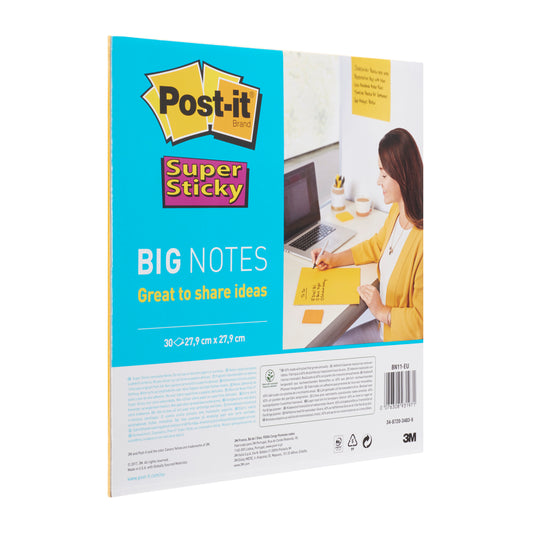 Eine Person schreibt an einem Schreibtisch auf einem 3M Deutschland GmbH Post-it® Super Sticky Big Notes BN11-EU Block (279x279mm, gelb, 30 Blatt, 100% PEFC). Die Verpackung mit Branding und Info ist neben einem Laptop und einem Notizbuch zu sehen.